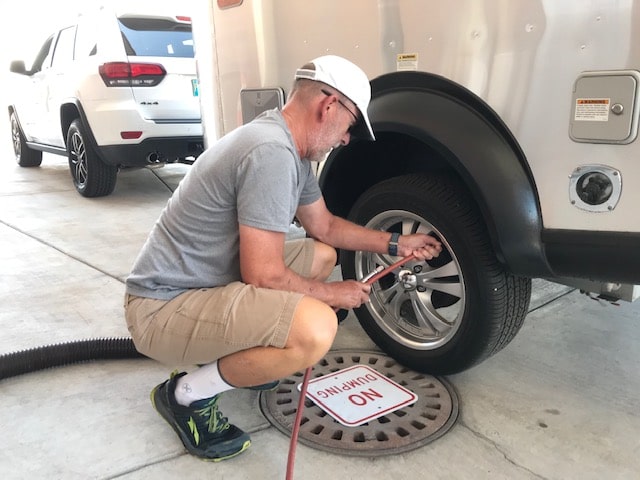 man airing up RV tire